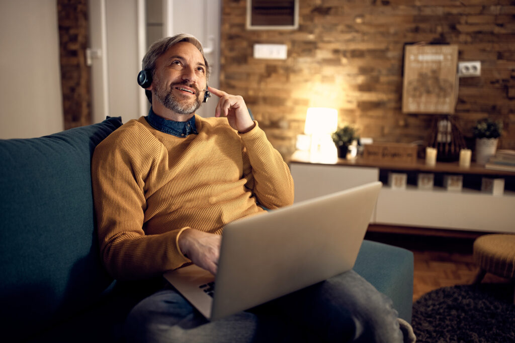 Businessman on laptop at home on conference call